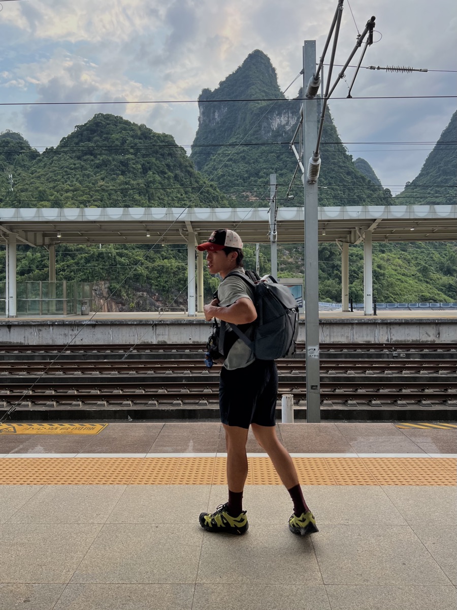 Howard Wong on a train platform in the mountains